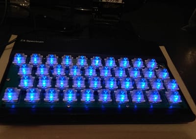 Vista en perspectiva spectrum original con teclado mecánico y LEDs encendidos. En esta ocasión con teclas transparentes y adhesivos transparentes.