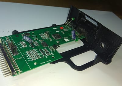 PCB colocado en soporte. LED, pulsadores y USB introducidos por sus orificios. Vista posterior.